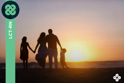 Photograph of family standing at sunset on the beach