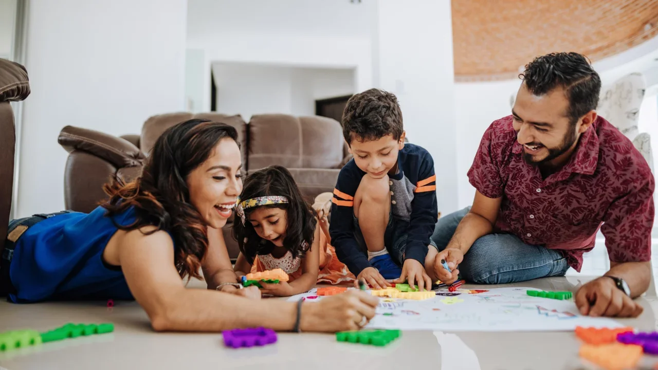 family drawing together on the floor of their home