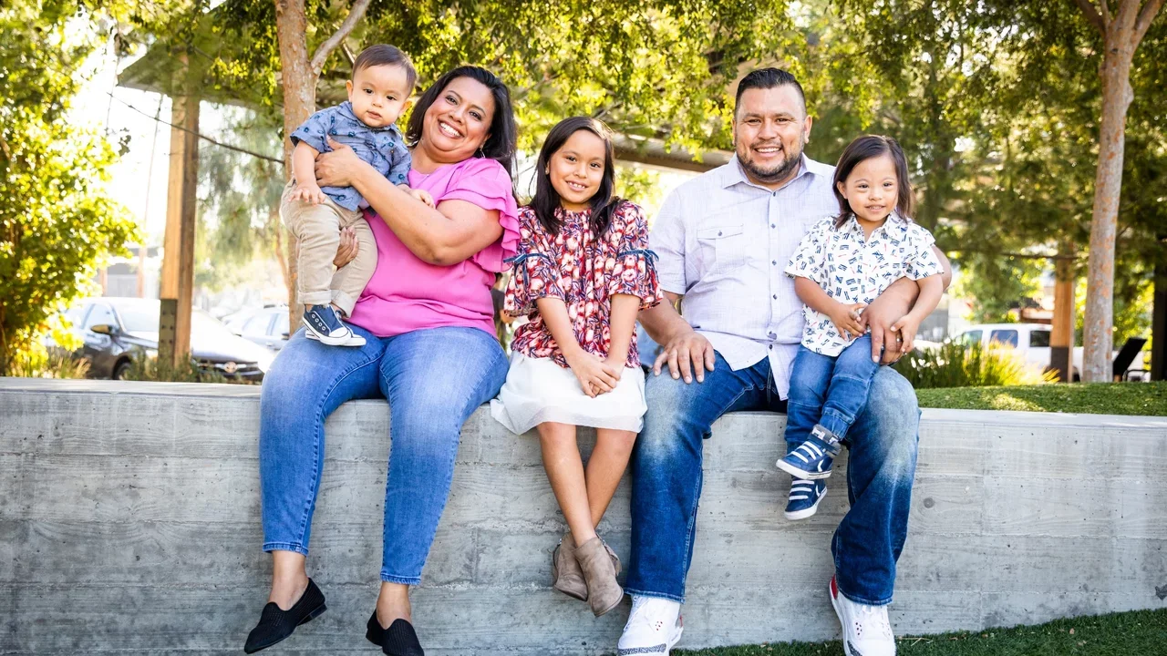 Photograph of a family sitting outside while smiling