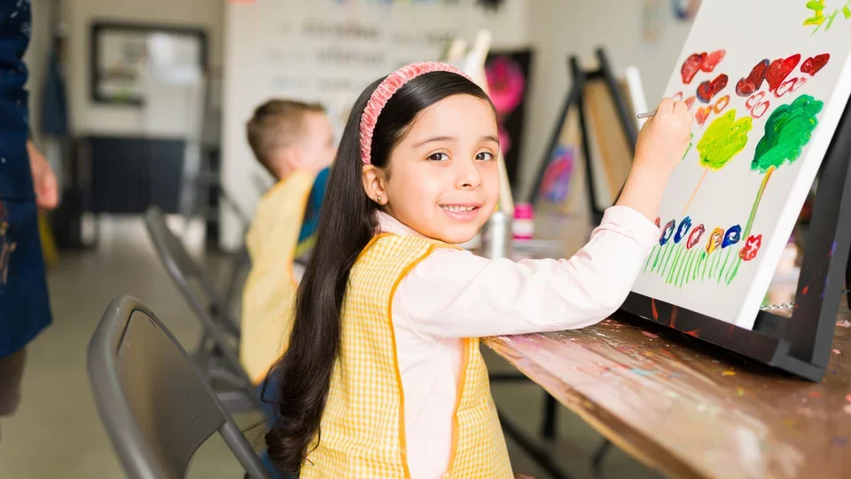 Photograph of a young girl painting in an art class