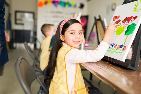 Photograph of a young girl painting in an art class