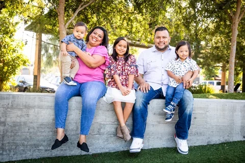 Photograph of a family sitting outside while smiling