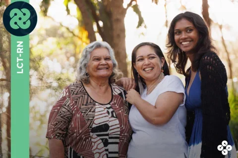 Photograph of family smiling with trees in the background.