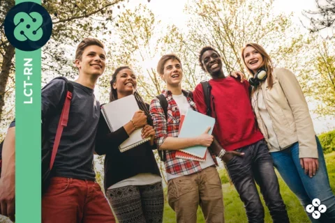 Photograph of five teenagers smiling on a sunny day