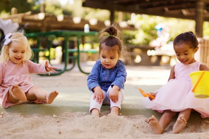 little children sitting in sandbox