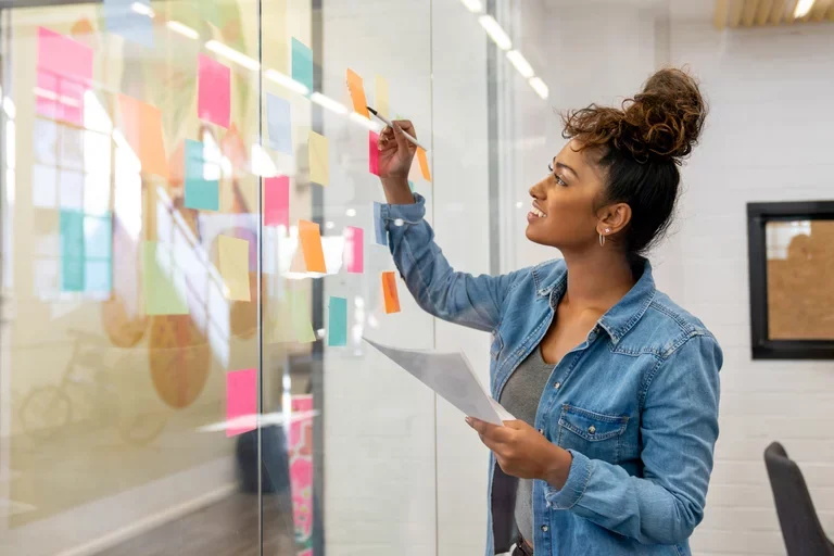 Woman putting stickers up on a glass window.