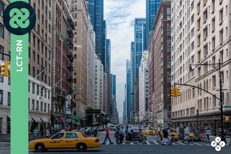 Photograph of busy city streets with lots of people, buildings, and cars.