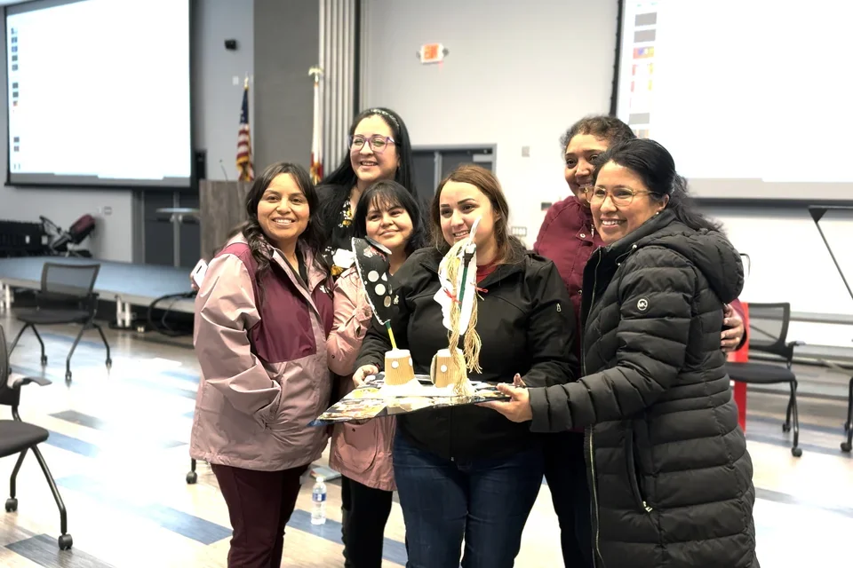 Photograph of a group of Creative Assembly participants holding up artwork