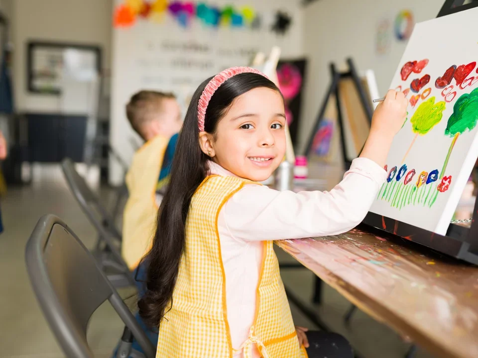 Photograph of a young girl painting in an art class