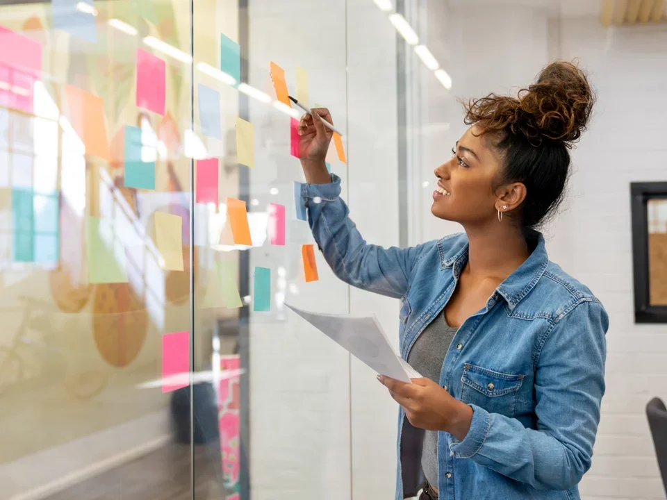 Photograph of a woman putting stickers up on a glass window.