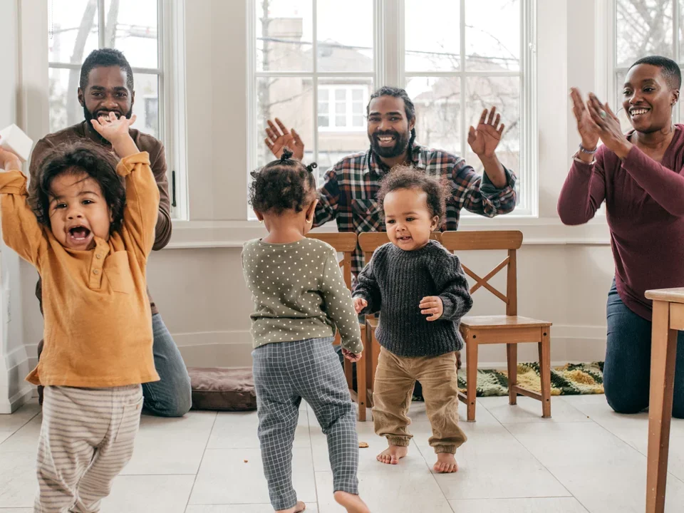 Photograph of three parents playing with their children.