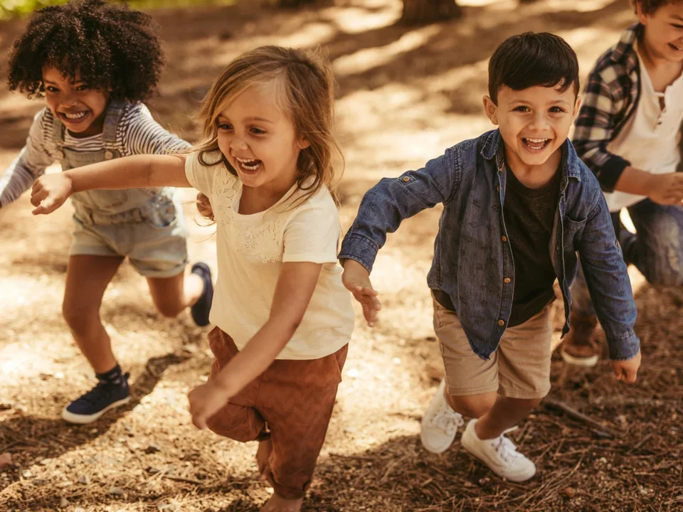 Four children running and laughing at midday
