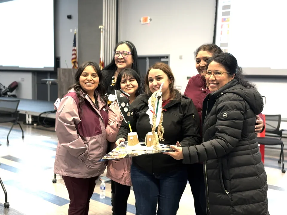 Photograph of a group of Creative Assembly participants holding up artwork