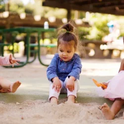 little children sitting in sandbox
